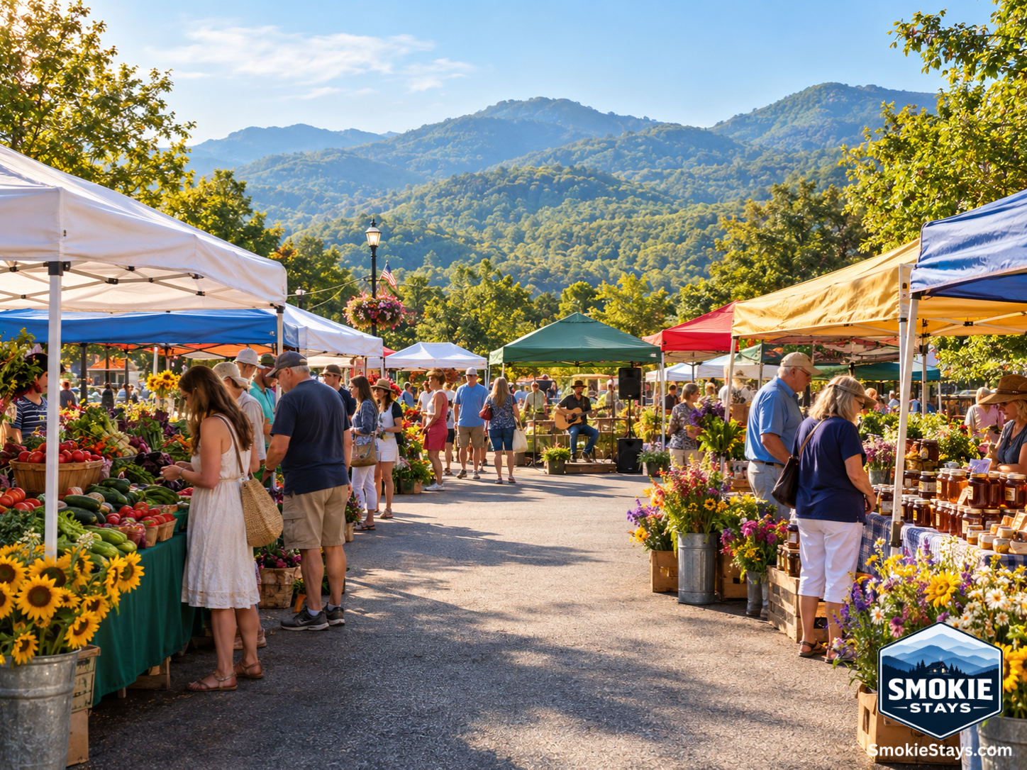 Shoppers browse colorful vendor stalls at the Gatlinburg Farmers Market on a sunny Saturday morning, with fresh produce, local honey, and homemade goods on display and forested Smoky Mountain ridges visible in the background.
